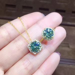 Macro shot of 3ct green moissanite necklace and ring set with golden finish