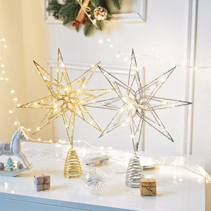 Golden and silver hollow iron Christmas tree toppers with warm LED lights in festive decor