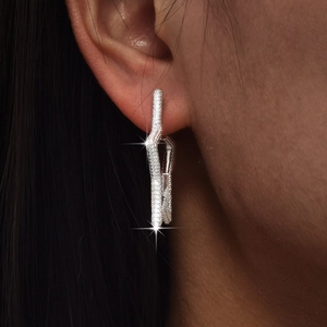 Close-up of sparkling star-shaped earrings with full diamond inlay on a model