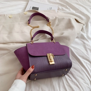 Detail of purple crocodile-patterned PU leather and matte suede with golden lock