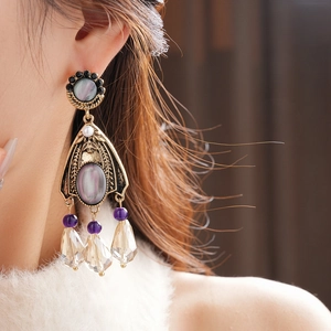 Close-up of vintage flower tassel earrings with crystals and pearls on model