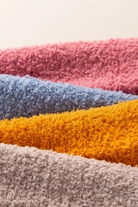 Close-up detail of soft coral fleece socks in pink blue yellow and taupe colors