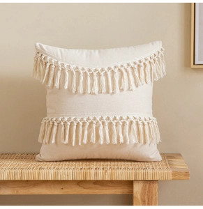 Close-up of beige bohemian tassel cushion cover made of textured cotton linen fabric