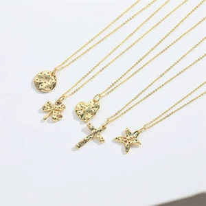 Close-up of five gold necklaces with colorful zircon clover and heart shaped pendants