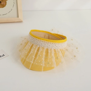 Detail of yellow toddler sun hat featuring cream lace trim and golden polka dot mesh fabric