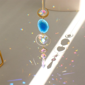 Detail of suncatcher prism casting colorful rainbow reflections on light background