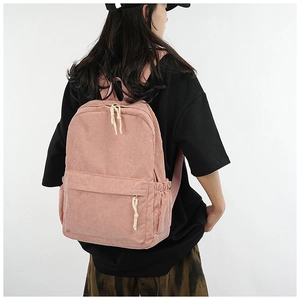 Pink corduroy backpack shown on a model for a realistic perspective on size and daily wear