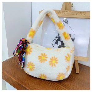 Close-up of white plush handbag with yellow daisy prints and a decorative silk scarf