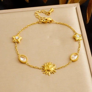 Gold stainless steel bracelet featuring sun pendant and star charms with sparkling gems