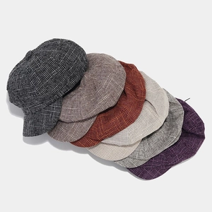 Flat lay of vintage newsboy caps in various colors with textured tweed fabric detail