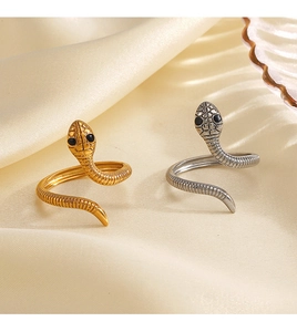 Primo piano di anelli a forma di serpente oro e argento con trama a scaglie