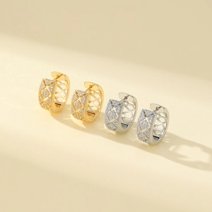 Macro shot of gold and silver hollow geometric rhinestone hoop earrings on warm background
