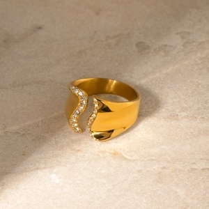 Gros plan sur une bague irrégulière en acier doré 18 carats sertie de zircons brillants