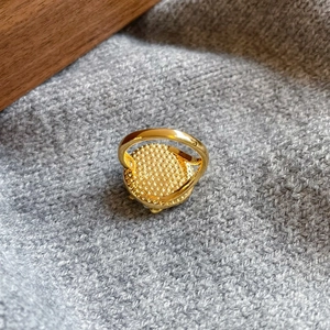 Close-up of the golden ring back featuring refined granular texture and polished finish