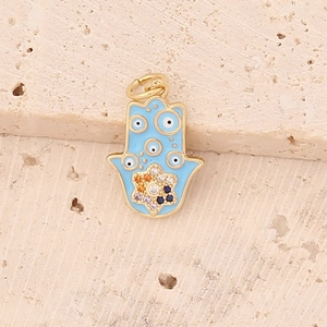 Detailed macro view of golden Hamsa hand pendant with blue enamel and colorful crystals