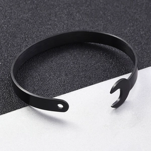 Macro shot of industrial black wrench open bangle with metallic texture and screw detail