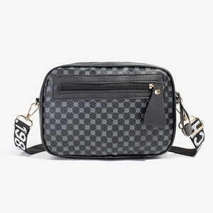 Black quilted crossbody camera bag with grey polka dots and adjustable numeric strap