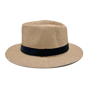 Detail of khaki woven paper straw sun hat with black ribbon band and textured weave