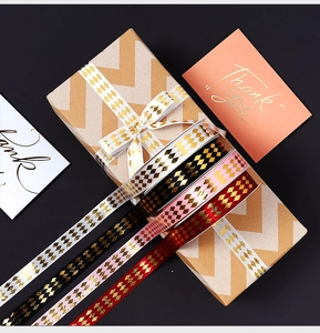 Detail of gold foil diamond ribbon on gift box with Thank You card and bow decoration