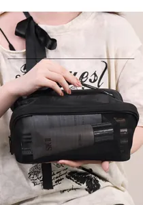 Close-up of black mesh cosmetic bag with handle showing interior storage capacity