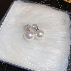 Close-up of elegant silver drop earrings with white pearls and sparkling crystals