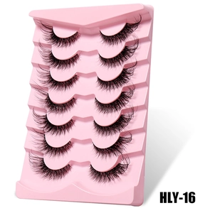 Detail view of 7 pairs of fox-eye false eyelashes with clear bands on a pink tray