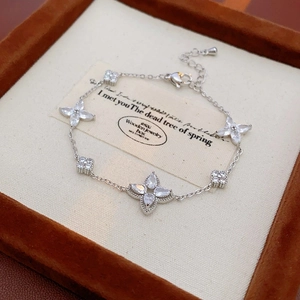 Detailed macro view of silver clover bracelet with sparkling zircons on velvet