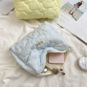 Quilted cloud cosmetic bag set in blue and yellow showing spacious interior storage