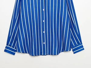 Détail de la texture rayée verticale bleue et blanche et du poignet à bouton blanc
