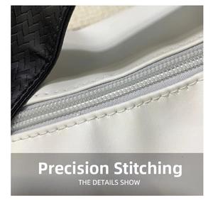 Macro shot of precision stitching and zipper detail on black and white textured PU bag