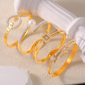 Set of four gold-plated hollow bangles with pearls, geometric shapes and star patterns