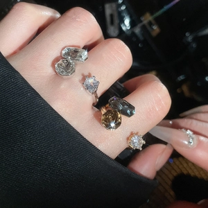 Macro detail of large-cut zircon rings with claw setting on model fingers