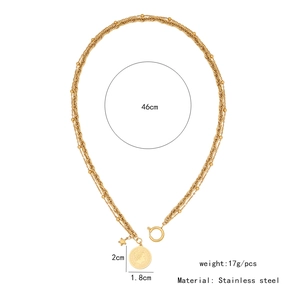 Close-up of gold double-layer stainless steel necklace with coin and star charms