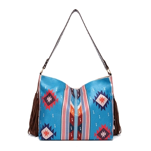Detailed view of bohemian tote bag with blue ethnic patterns and long side tassels