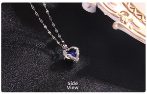 Detail view of heart-shaped necklace with deep blue crystal and silver wave chain