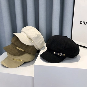 Close-up of four colors of newsboy caps in textured tweed with metal buckle detail