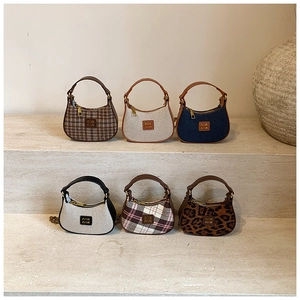 Détail de mini sacs hobo avec motifs léopard, carreaux et finitions en denim bleu
