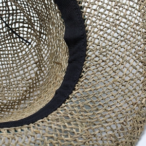 Close-up of the breathable hollow weave texture and black inner sweatband of the straw hat