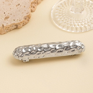 Detail of silver hammered metal hair clip showing textured surface and minimalist design