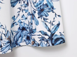 Detailed view of blue floral print on white chiffon fabric with fine stitching quality