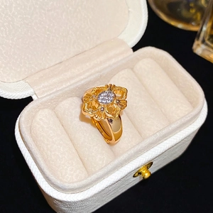 Vintage 24K gold plated flower ring with sparkling cubic zirconia on white leather