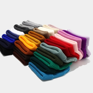 Détail des bonnets en maille côtelée dans une palette de couleurs arc-en-ciel vives