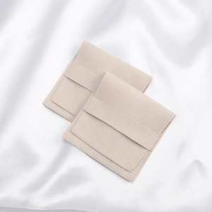 Macro shot of beige microfibre jewelry envelopes with premium stitching on silk fabric
