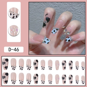 Long ballet press-on nails with cow print, 3D bows, and rhinestone chain accents
