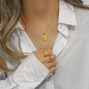 Elegant 18K gold-plated stainless steel starburst pendant necklace worn by a model