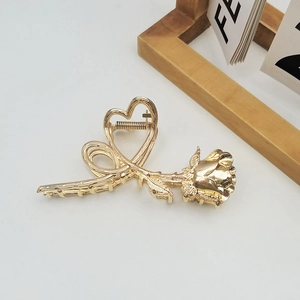 Golden heart and rose metal hair claw clip displayed on a clean white background