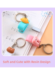 Detail of mini cartoon animal stapler keychains with resin charms on school notebook