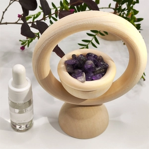 Vertical wooden ring diffuser stand with purple crystal stones and a glass essential oil dropper