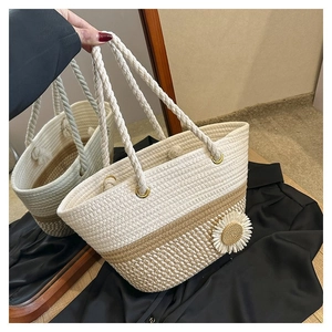Detail of hand-woven cotton rope tote bag featuring a white daisy flower decoration