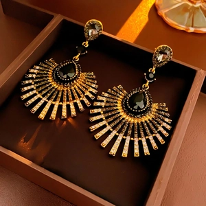 Vintage gold teardrop tassel earrings with black crystals and pavé diamonds in a jewelry box